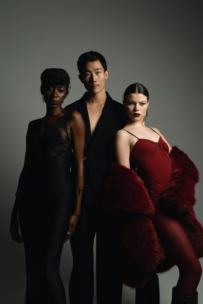Stylish fashion portrait of three models in a sophisticated studio setup.