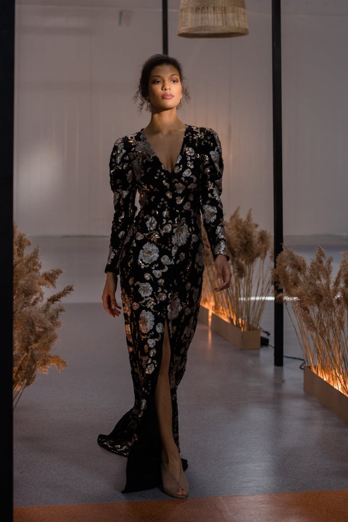 Stylish model walking on a fashion runway in an elegant floral dress.