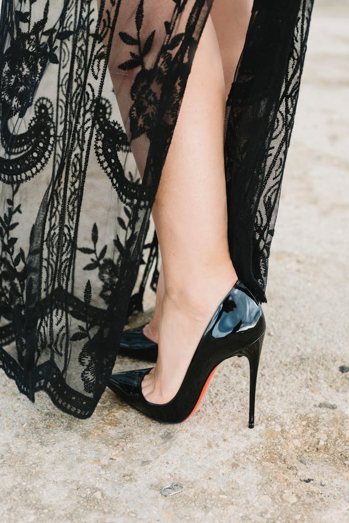 Stylish black high heels paired with a lace dress in an elegant close-up shot.